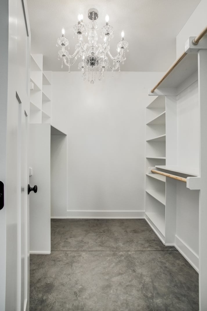 Luxurious walk-in closet with built-in shelving and a crystal chandelier