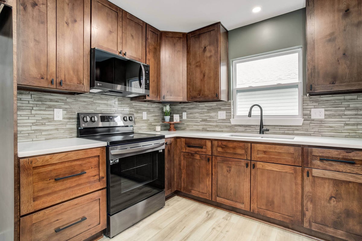 Modern kitchen with stainless steel appliances, wood cabinets, and a subway tile backsplash