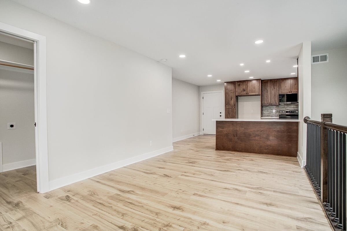 Renovated living room with an open floor plan, modern ceiling fan, and large windows in Burton